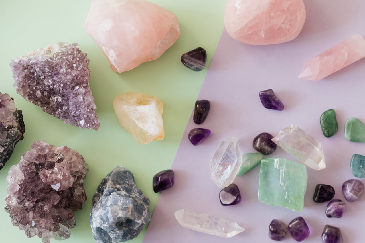 heros-img A variety of crystals and gemstones including amethyst and rose quartz on a pastel background.